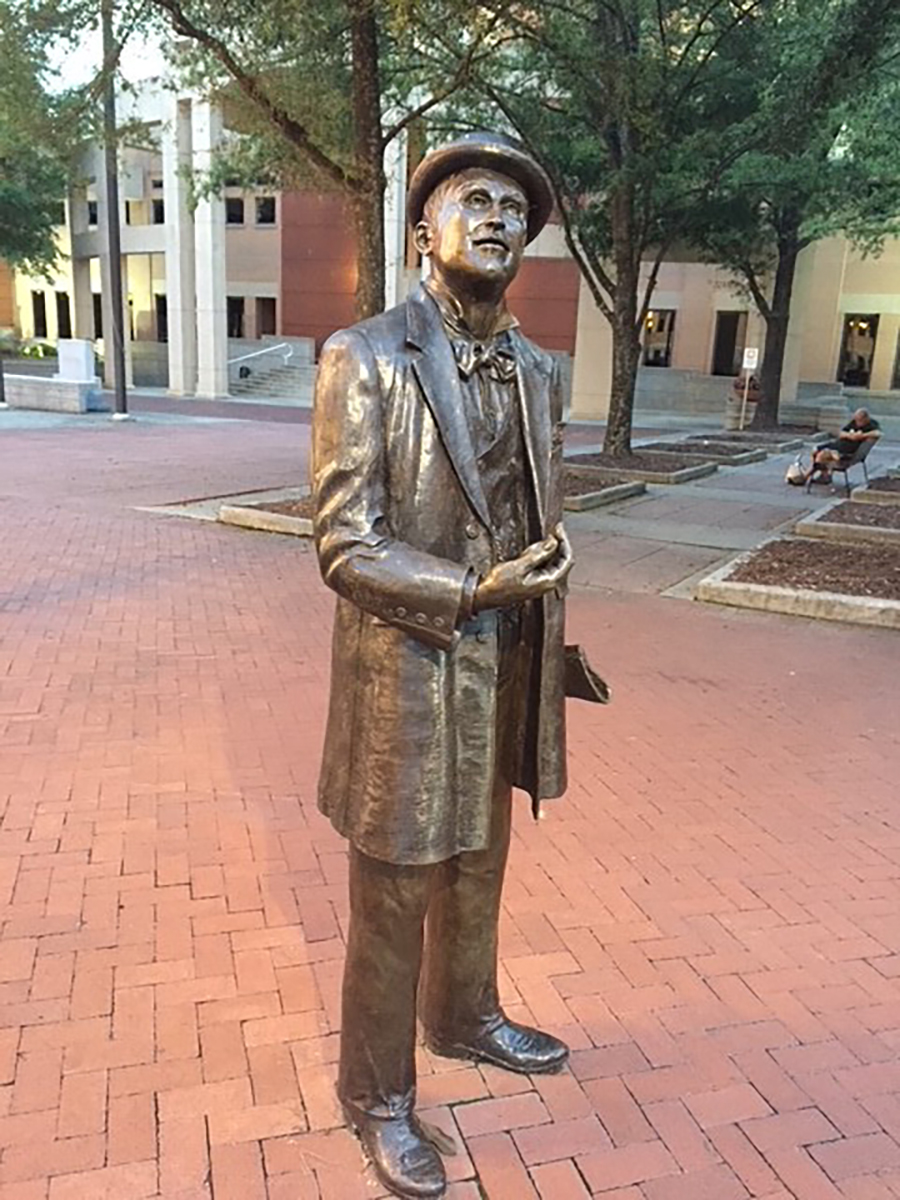 The statue of William Church Whitner, who conceived the pioneering electric system in Anderson, gazes up at a streetlight. Photo: City of Anderson.